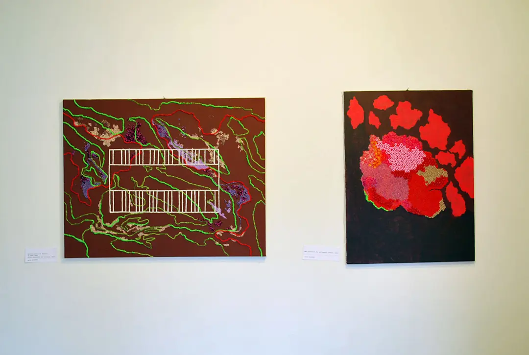 Two bead paintings. The one on the left has a brownish background with red, purple, and 
                    green lines of beads in squiggle patterns. In the center is a white grid. The painting on the right 
                    has a grey background with red splotches. The biggest splotch in the center is covered in 
                    multicolored beads.