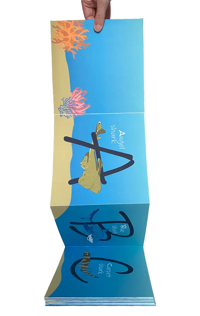 Front view of a three-dimensional collage on a painted board. It's made of miscellaneous 
                    trash, including strings of beads, plastic, and a circus cutout from a children's book.